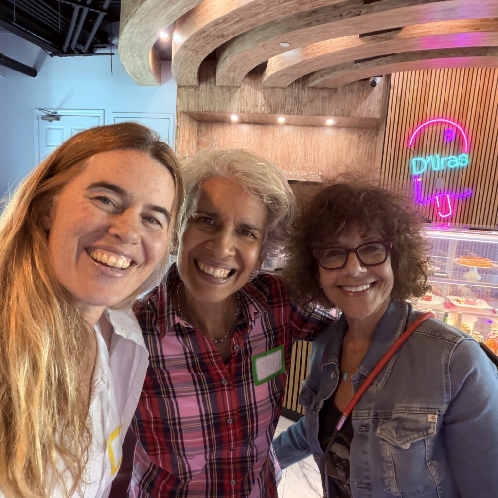 Three friends smiling at a café gathering